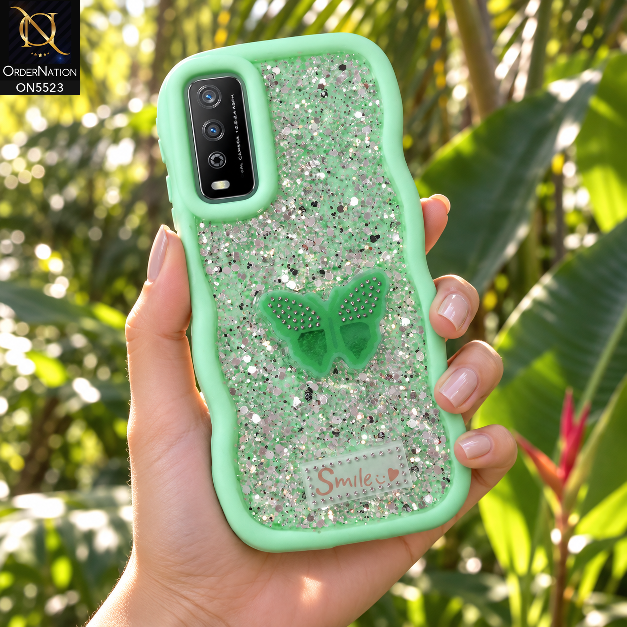 Vivo Y11s Cover - Sea Green - New Premium Smile Glitter Soft Case on the phone, held in a hand in a tropical garden (AI lifestyle render)