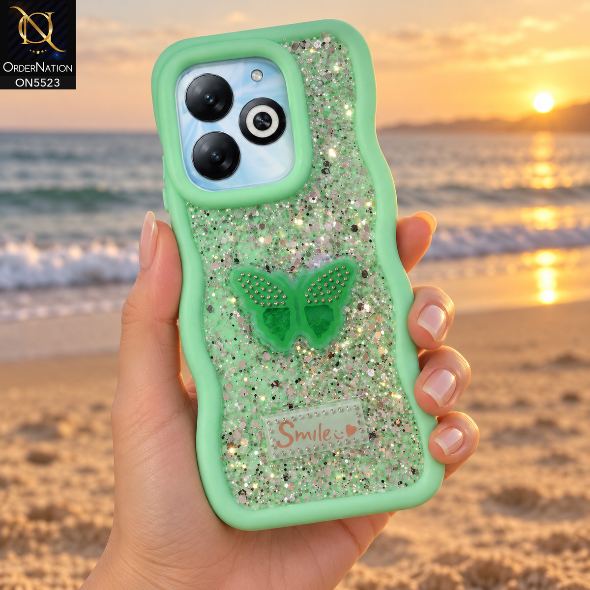 Infinix Smart 8 Pro Cover - Sea Green - New Premium Smile Glitter Soft Case on the phone, held in a hand on a beach at sunset (AI lifestyle render)