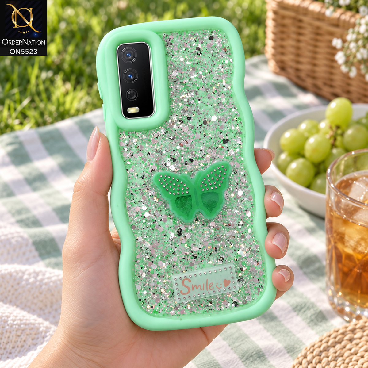 Vivo Y12s Cover - Sea Green - New Premium Smile Glitter Soft Case on the phone, held in a hand at a park picnic (AI lifestyle render)