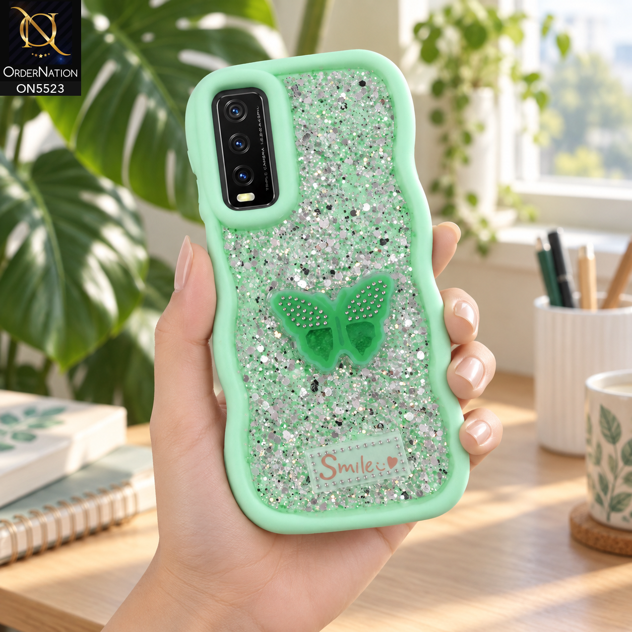 Vivo Y20 Cover - Sea Green - New Premium Smile Glitter Soft Case on the phone, held in a hand in a study corner with a monstera (AI lifestyle render)