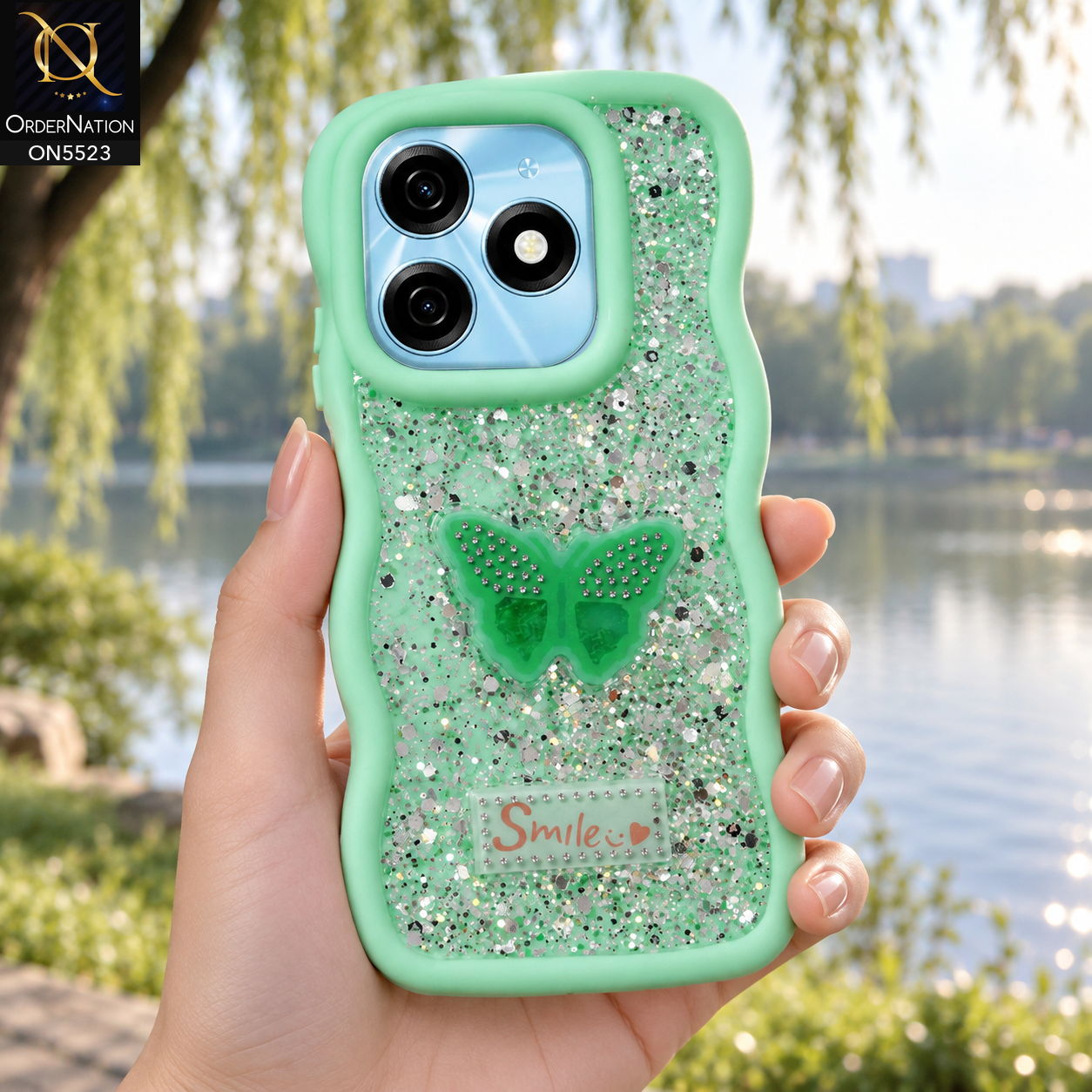 Tecno Spark 20 Cover - Sea Green - New Premium Smile Glitter Soft Case on the phone, held in a hand by a lake in a park (AI lifestyle render)