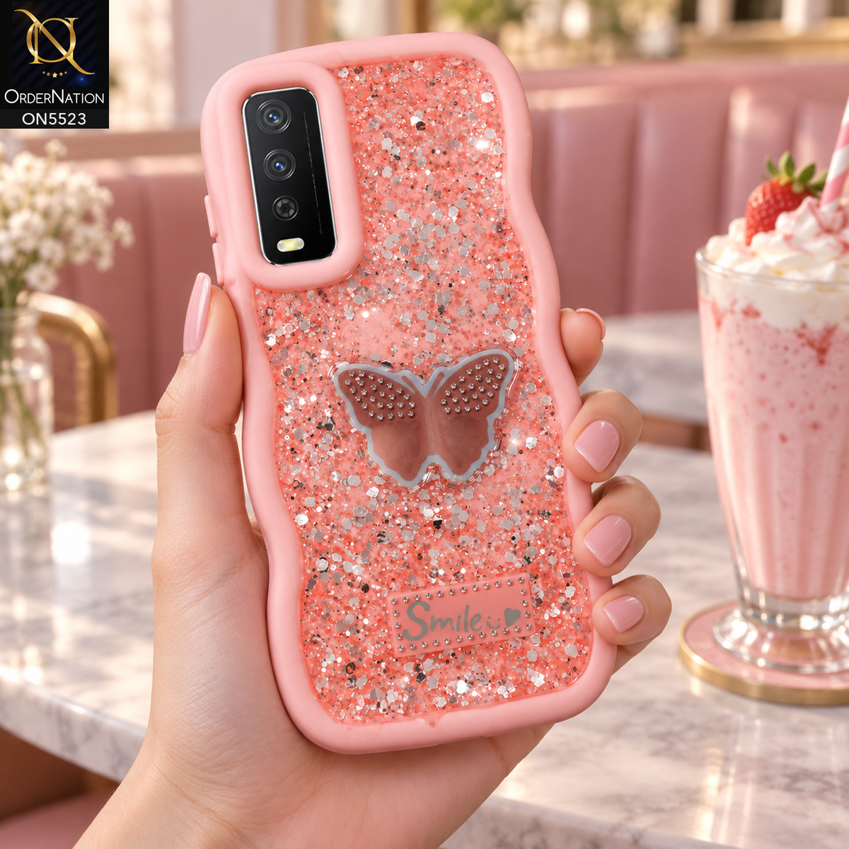 Vivo Y11s Cover - Pink - New Premium Smile Glitter Soft Case on the phone, held in a hand in a pink cafe with a milkshake (AI lifestyle render)